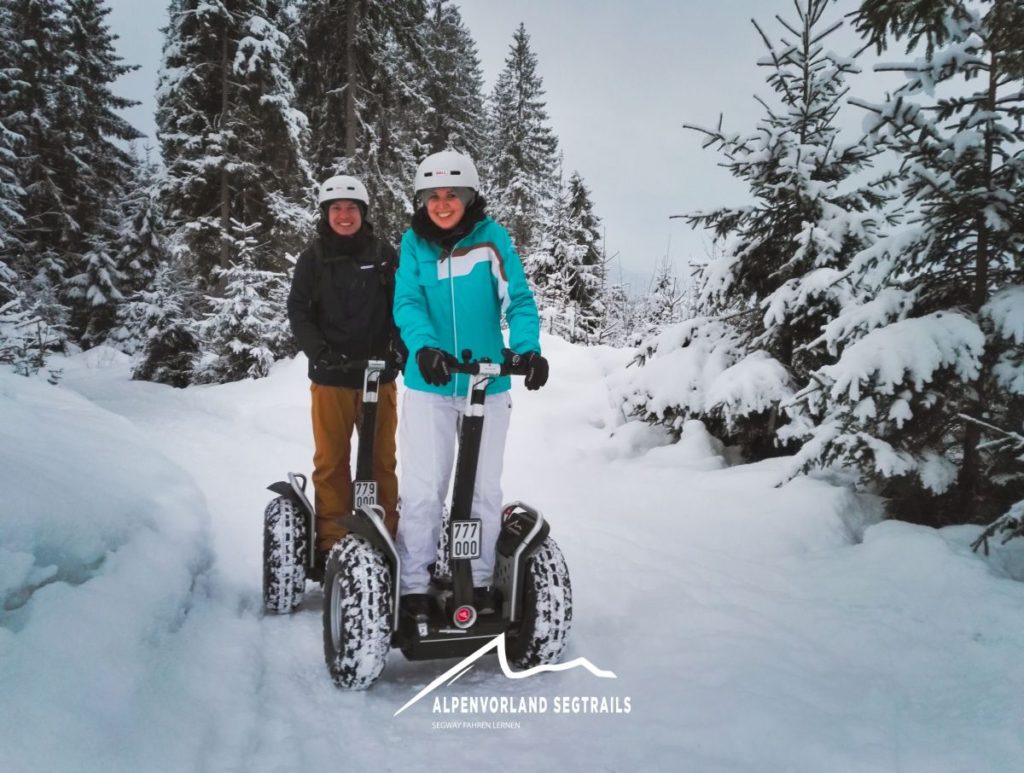 Zwei Segway Fahrer, mit dicker Winterbekleidung im tiefen Schnee